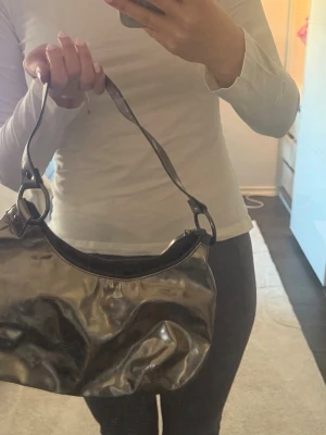 Silvrig väska  - Säljer en silvrig handväska, gammal från HM. Fint skick ❤️