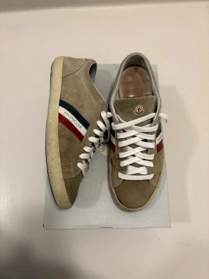 Moncler skor - Beiga/bruna Moncler mocka skor //  Storlek 41 //  Mycket bra skick väldigt lite slitna på sulan men väldigt sparsamt använda //  Extra skosnöre ingår //  Skriv vid minsta fråga eller fundering🤝 