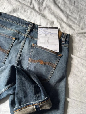 Ljusblåa Heavy worn selvage nudie jeans - Säljer nu dessa stilrena heavy worn selvage nudie jeans i modellen lean dean. Byxorna har en rak och bekväm passform. Det är i ett mycket bra skick då jag bara har använt dem ett få antal gånger. W31 L30 jag är 184 och väger 77. Vid frågor och funderingar hör gärna av er! mvh.