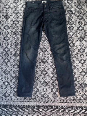Mörkblå slim fit jeans från Jack and Jones  - Snygga mörkblå jeans från jack&jones  med slim fit passform och klassisk femficksdesign. Jeansen har raka ben och subtila slitningar för en modern look. Tillverkade i ett mjukt och stretchigt denimtyg som sitter skönt hela dagen. Dessa är riktigt schyssta och inte använda speciellt mycket. Inga tecken på skador eller liknande. Modellen är Slim glen i storlek 30/32 men dessa passar perfekt ner till 28/32 också 