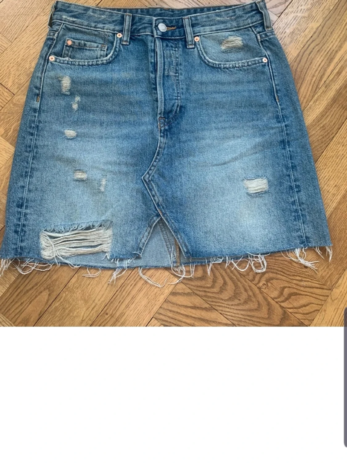 Blå jeanskjol med slitningar