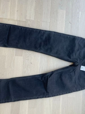 Svarta jeans - Säljer ett par svarta jeans med en rak passform. Jeansen har en enkel look utan slitningar och är tillverkade i stretchigt denimtyg för extra komfort. Prislappen är kvar och de är aldrig använda. Jeansen är från lager 157 och är i modellen ICON. Pris kan diskuteras.
