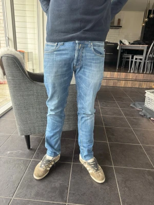 Grover jeans  - Säljer ett par ljusblå slim fit jeans från replay med klassisk femficksmodell och snygga slitningar. Jeansen har normal midja, dragkedjegylf och replay-lapp bak i midjan. Perfekta för en avslappnad och trendig look. Modellen är grover 