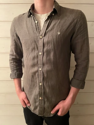Morris linneskjorta - Snygg olivgrön skjorta i linne med klassisk krage och vita knappar. Skjortan är i fint skick.   Om ni undrar något fråga gärna!