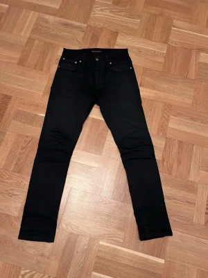 Nudie Jeans Grim Tim  - Ett par super schyssta Nudie jeans i en svart färg. Storlek 30w32L. Bra skick och inte tvättade många gånger. Bra skick