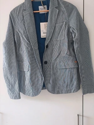 Helt ny Peak Performance kavaj - Peak Performance kavaj för dam. Helt ny med tags. Bomullsmaterial och blått innerfoder ger en fräsch känsla. Perfekt för en stilren look. Storlek S