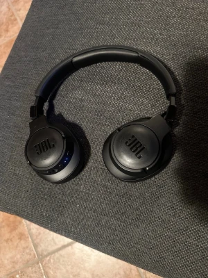 Jbl hörlurar TUNE760NC - Jag har ett par Jbl hörlurar som jag brukade använda för att lyssna på musik för att lugna ner mig, jag har bytt till wireless nu och tänkte sälja dem. Allt fungerar perfekt som det ska knapparna på den också, Men jag har tappat bort laddaren men kan fixa en ny till köparen. Jag har haft dem i 1 år och använt dem i ungefär ett halvt år. Och dem är perfekt för vardags träning eller jogg dem sitter perfekt så att dem inte trillar ut