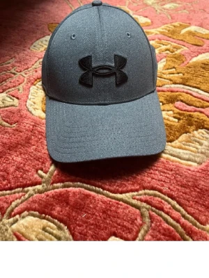 Mörkgrå keps från Under Armour - Snygg mörkgrå keps från Under. Storlek S/M skick 9/10
