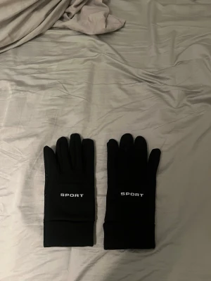 Svarta sporthandskar med grepp - Varma och sköna. Funkar att använda telefon med dom på.
