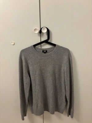 Grå stickad cashmere tröja från Uniqlo - En stilren grå stickad cashmere tröja från Uniqlo med rund halsringning och långa ärmar. Den är i bra skick och storlek medium men passar mer storlek small.