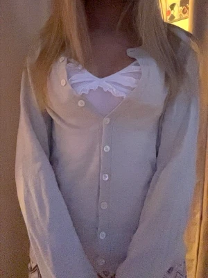 Beige kofta med knappar - Söt beige kofta med v-ringning och vita knappar framtill. Jättebra material, nypris 1700