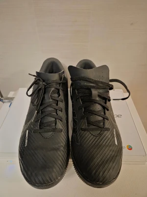 Nike Mercurial svarta fotbollsskor - Säljer ett par svarta Nike Mercurial fotbollsskor för INOMHUS. Skorna har en modern, slimmad design med diskreta ränder och Mercurial-logga på sidan. Ovandelen är i syntetmaterial som ger bra bollkontroll och passform. Använda 1 gång.