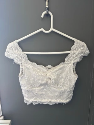 Vit spetsig croppad topp - Vit spets top, täckande runt byst, croppad.