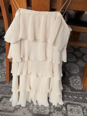 ljusgul volangklänning  - Säljer en superfin ljusgul kortklänning med flera lager volanger och tunna axelband. Aldrig använd.