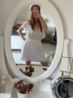 Student klänning  - Säljer en söt vit kortklänning med volangdetaljer och resår i midjan. Använd endast en gång och är i mycket bra skick! Perfekt som student klänning! Är från Vera Moda!