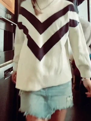 Vit stickad tröja från GANT - Vit stickad tröja från GANT med svarta V-formade ränder över bröstet och armarna. Tröjan har polokrage och är ribbstickad i ett mjukt material. Perfekt för dig som gillar klassisk men trendig stil.