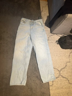 Ljusblå  jeans i denim - Säljer ett par ljusblå jeans i relaxed Baggy modell. Jeansen är tillverkade i kraftig denim. Passar perfekt till en avslappnad och trendig stil. Inga synliga slitningar eller detaljer utöver den klassiska looken.