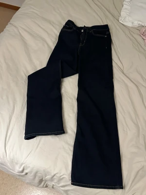 Mörkblå raka jeans med kontrastsömmar - Säljer ett par mörkblå jeans med raka ben och vita kontrastsömmar. Klassisk femficksmodell och normal midja. Perfekta till en avslappnad stil och passar till det mesta. Materialet är denim i bomull. Storlek xs/34. Från only