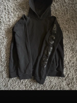 Svart hoodie från Acne Studios - Säljer en svart hoodie från Acne Studios med tryckt logga längs ena ärmen. Den e vintage och skit snygg. Storlek L men passar M också 