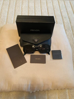Solglasögon Prada - Säljer helt nya svarta par solglasögon som kommer med box och allt som finns med på bilderna💕💕 och passar båda tjejer och killar💗