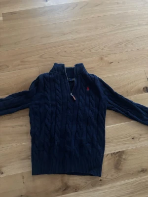 Mörkblå kablestickad Ralph lauren tröja - Mörkblå kabelstickad tröja från Ralph Lauren, storlek M 175. Använd 1-2 gånger 