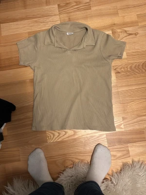 Beige ribbad t-shirt från Kappahl - Säljer en beige ribbad t-shirt från Kappahl. Materialet är mjukt och stretchigt. Passar dig som gillar neutrala färger och enkel design.