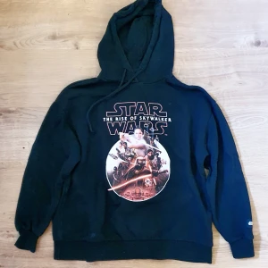 Star Wars hoodie stl 164 - Svart hoodie med stort Star Wars: The Rise of Skywalker-tryck på bröstet. Motiv med flera karaktärer från filmen och coola detaljer. Klassisk huva och ribbade muddar. Perfekt för dig som älskar Star Wars och vill ha en bekväm och snygg hoodie. Märkt storlek 165 cm (ca juniorstl L).