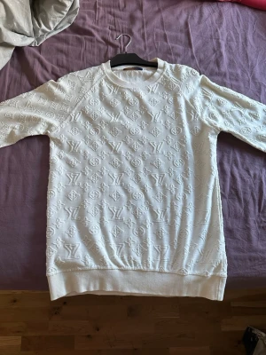 Vit Louis Vuitton sweatshirt - Säljer en vit sweatshirt från Louis Vuitton med det klassiska LV-monogrammet i ett upphöjt mönster över hela tröjan väldigt unik 