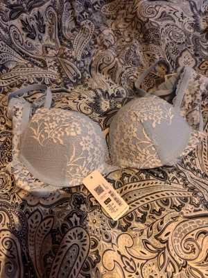 Ljusblå spets-bh med blommönster - Helt ny, köpte i förrgår den finaste bhn, tyvärr för liten. 70A. Söt ljusblå push-up bh med vit spets med blommönster. Axelbanden är justerbara och sidorna har genomskinlig spets. Pris kan diskuteras💕 
