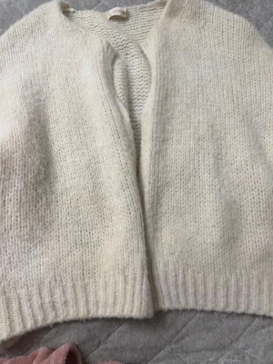 Krämvit stickad kofta - Krämvit/beige/ ljus aprikos färgad kofta. Den är stickad och väldigt fin till en sommarkväll. Storlek S.