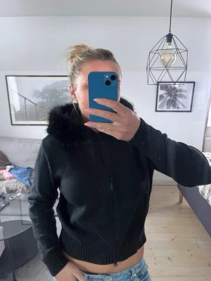 Stickad Hoodie/cardigan från Gina tricot - Svart stickad hoodie/cardigan med luva från Gina tricot YOUNG 14+! Storlek L men eftersom de är Young modell så passar den S-M