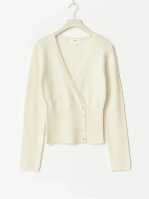 Vit omlottkofta med knappar - Snygg vit omlottkofta från Monki med djup v-ringning och dekorativa knappar framtill. Koftan har lång ärm och är tillverkad i ett mjukt, stickat material som känns skönt mot huden. Perfekt för lager-på-lager och enkel att styla.