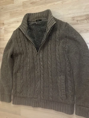 Fodrad sticksd cardigan - Otroligt snygg, varm och skön grå fodrad stickad cardigan med fina mönster. Passar perfekt till kallare väder. Priset kan såklart diskuteras!
