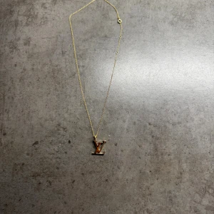 Louis Vuitton reworked halsband  - Helt nytt åter gjort halsband med Louis Vuitton smycke på en 925 sterling silver 18 k pläterad länk på som är 45cm och går att justera till önskad passform. Jag har gjort detta halsband själv med äkta original Louis Vuitton delar från ett annat Louis Vuitton armband och sedan satt ihop det med ett halsband. Äkthetsgaranti på halsbandet och inga problem med hållbarheten då det är kvalité. Halsbandet är helt nytt och själva Louis Vuitton delen är helt ny också! Perfekt julklapp som inte kostar någ