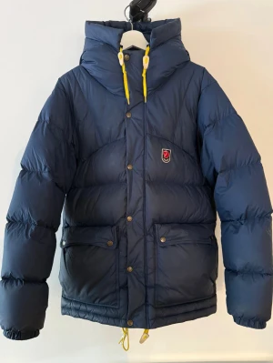 Mörkblå dunjacka från Fjällräven - Säljer min fjällräven jacka i storlek S. Det är en herrmodell, men har använt den som tjej.  Nypris 7000 kr. 💕