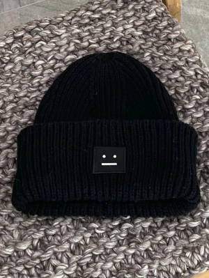 Acne mössa - Superfin populär mössa från Acne Studios. Eftertraktad sällsynt modell med vit facepatch i stället för helsvart. Varsamt använd utan slitage/fläckar. Ej krympt i tvätt. 100% ull. Skickar inom 24h🤍✨
