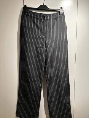 Kostymbyxor  - Säljer dessa kostymbyxor från Kappahl med en mellan låg midja och raka ben. Super snygg passform med fickor fram och fake fickor bak. storlek 38 men passar även 36.