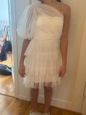 Vit one shoulder klänning - Supersöt klänning. Köpt av en tjej som hade den på sin student men va tyvärr för liten för mig. Jag skulle säga att den e liten i storleken, typ Xs. Den är från by malina men säljs inte längre. Perfekt till studenten