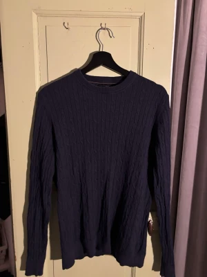 Massimo dutti skjorta - Mörkblå kabelstickad tröja med rund halsringning och långa ärmar. Tröjan har ett klassiskt mönster med smala flätor och ribbade muddar vid ärmslut och nederkant. Perfekt för lager på lager och enkel att matcha till olika outfits.