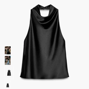 Svart halterneck topp i satin från Zara - Snygg svart halterneck topp från Zara med draperad krage i glansigt satinmaterial. Toppen är ärmlös och har en elegant, lös passform som ger en lyxig känsla. Perfekt att styla med jeans eller kjol för en trendig look.