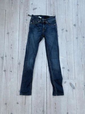 Marinblå jeans från Tiger of Sweden - Snygga mörkblå jeans med klassisk femficksdesign och kontrastsömmar. Jeansen har   raka ben, perfekta till en avslappnad stil. Materialet är denim i bomull med lite stretch för extra komfort.