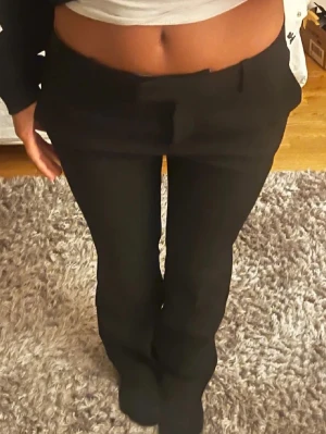 Svarta kostymbyxor med bootcut - Säljer ett par svarta kostymbyxor från Zara men köptes här på Plick. Bilderna är lånade från tjejen jag köpte från. Säljer dem då de är för korta för min smak, är 160cm
