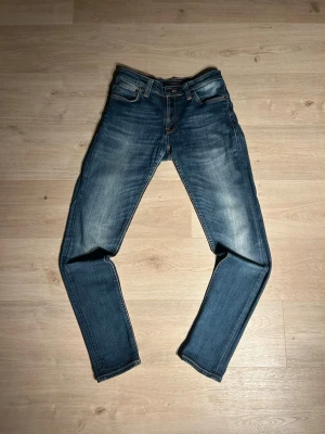 Blåa Nudie Skinny Lin Jeans Storlek W28 L32 - Fina Nudie Jeans i blå färg. Jeansen är i mycket bra skick och sparsamt använda. |  Äkta som allt annat jag säljer! ✅|  Storlek: W28 L32 | Skick: Mycket Bra Skick | Färg: Blå | Märke: Nudie | Modell: Jeans |  Hör gärna av dig vid frågor så svarar jag så fort jag kan! 😁|  