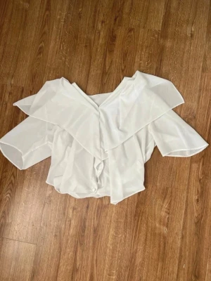 Vit blus med volang - Blus i lätt fint tyg.