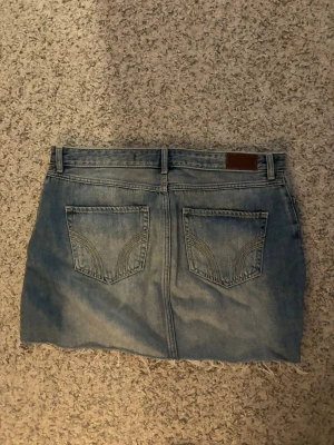 Ljusblå jeanskjol med fransig kant - Säljer en ljusblå jeanskjol i klassisk modell med fem fickor och fransig, rå kant nedtill. W30🌺🌺