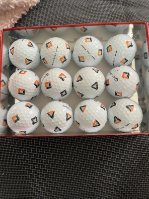 TaylorMade golfbollar med mönster tp5 - Säljer ett dussin vita golfbollar från TaylorMade med unikt orange och svart mönster. Bollarna har klassisk dimple-yta och är märkta med TaylorMade-loggan. Perfekt för dig som vill sticka ut på golfbanan. 