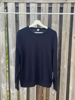 Mörkblå Arket sweatshirt - En enkel svart sweatshirt med rund hals och långa ärmar. Tröjan har en klassisk passform och ribbade muddar vid ärmslut och nederkant. Perfekt att matcha med jeans eller över en t-shirt för en clean look. Står L på tröjan men skulle säga att den passar mer till M.
