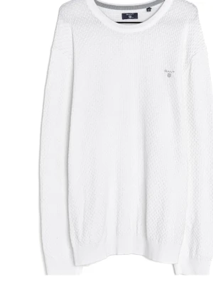 Vit stickad tröja från Gant - Klassisk vit stickad tröja från Gant med rund halsringning och diskret logga broderad på bröstet. Tröjan har lång ärm och ribbade muddar vid ärmslut och nederkant. Tillverkad i mjukt material som ger en clean och stilren look.