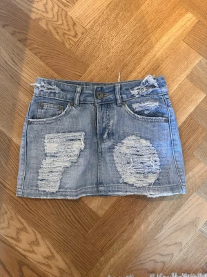 Jeans kjol - Supersnygg jeans kjol från märket miss yang. Midjemått rakt över 32cm och det andra måttet uppifrån o ned 27cm.