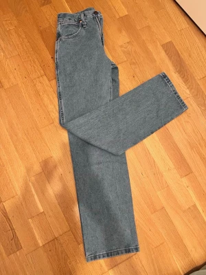  raka jeans 28/32 från Acne Studios - Säljer ett par blå raka jeans från Acne Studios i storlek 28/32. Jeansen har klassisk femficksdesign, dragkedja och är gjorda i bomull. Perfekta för dig som gillar en enkel och stilren look.